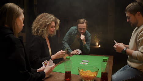 Gruppe-Von-Freunden,-Die-Poker-Spielen-Und-Zu-Hause-Auf-Stühlen-An-Einem-Tisch-Sitzen-3