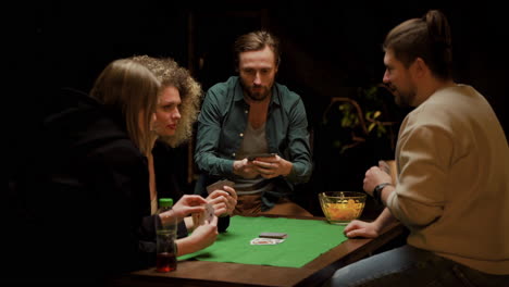 Gruppe-Von-Freunden,-Die-Poker-Spielen-Und-Zu-Hause-Auf-Stühlen-An-Einem-Tisch-Sitzen-5