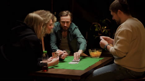 Gruppe-Von-Freunden,-Die-Poker-Spielen-Und-Zu-Hause-Auf-Stühlen-An-Einem-Tisch-Sitzen-6