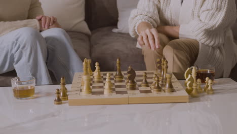 Zwei-ältere-Frauen,-Die-Zu-Hause-Auf-Dem-Sofa-Sitzen-Und-Schach-Spielen-3