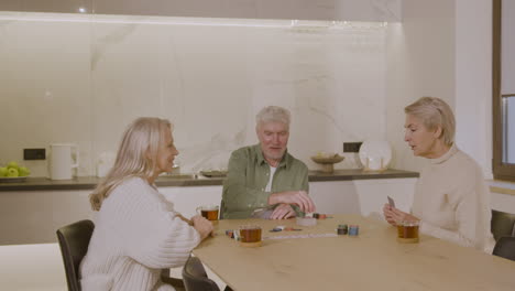 Drei-Glückliche-ältere-Freunde,-Die-Zu-Hause-Poker-Spielen