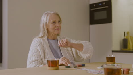 Senior-Woman-Playing-Poker-At-Home