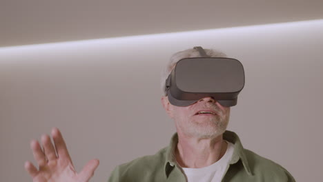 Senior-Man-Playing-At-Home-With-Virtual-Reality-Goggles-Headset-3