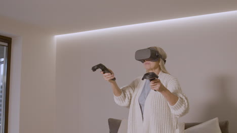 Senior-Woman-Playing-At-Home-With-Virtual-Reality-Goggles-Headset