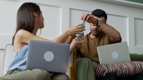 Student-Talking-With-Female-Mate-Sitting-On-Sofa-While-Looking-At-Laptop-2