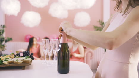Side-View-Of-A-Woman-Opening-A-Bottle-Of-Champagne-On-The-Table