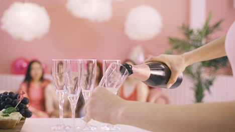 Seitenansicht-Der-Hände-Der-Frau,-Die-Champagner-In-Kristallgläser-Auf-Den-Tisch-Gießen