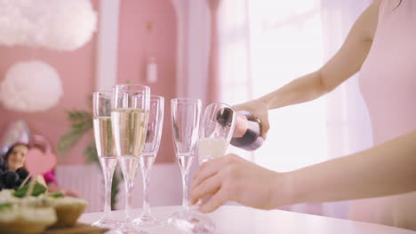 Close-Up-View-Of-A-Woman-Pouring-Champagne-In-Crystal-Glasses-On-The-Table