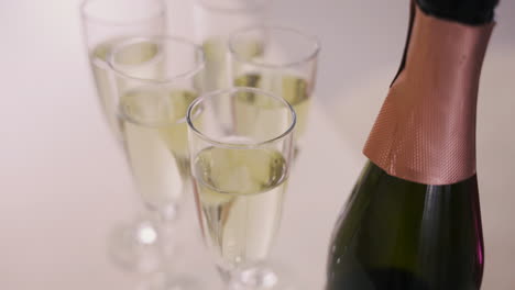 Blick-Von-Oben-Auf-Eine-Champagnerflasche-Und-Kristallgläser-Mit-Champagner-Auf-Einem-Tisch-Bei-Einer-Junggesellenparty