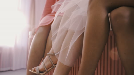 Side-View-Of-Female-Friends-LegÂ¬Â¥S-With-Silver-Heels-Who-Are-Sitting-On-Top-Of-A-Table-At-A-Bachelorette-Party