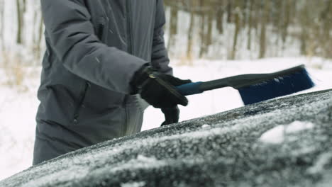 Close-Up-Of-An-Unrecognizable-Man-Cleaning-His-Car-From-Snow-With-A-Brush-In-A-Winter-Day