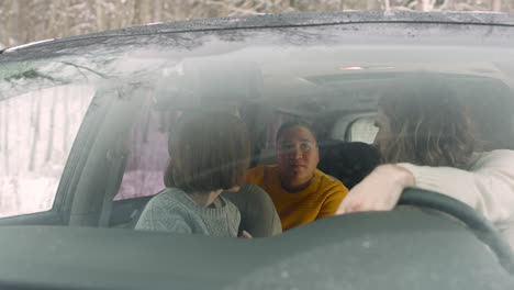 Drei-Freunde-Unterhalten-Sich,-Während-Sie-An-Einem-Wintertag-Im-Auto-Sitzen