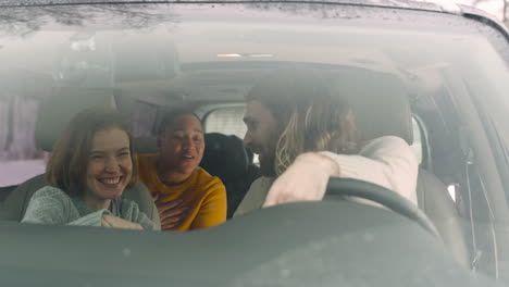 Three-Happy-Friends-Talking-And-Spending-Good-Time-Together-While-Sitting-In-The-Car-On-A-Winter-Day