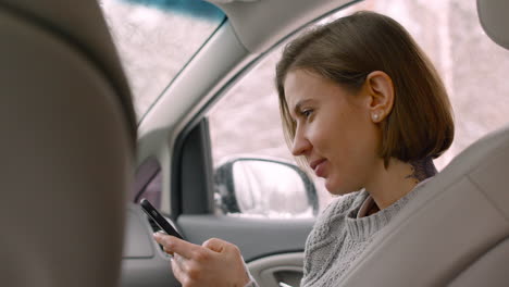 Woman-Using-Mobile-Phone-While-Sitting-On-Car-Passenger-Seat