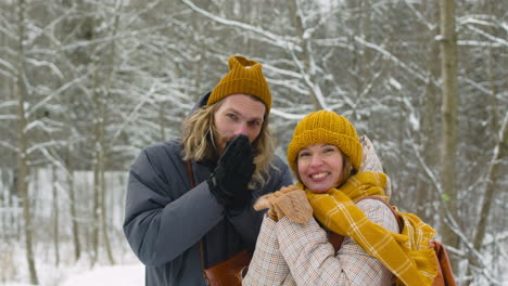 Man-And-A-Woman-Warming-Their-Hands-In-The-Snowy-Forest-1