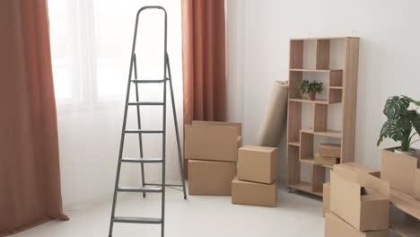 Moving-Boxes-And-Ladder-In-Empty-Room-Of-New-Home-1