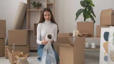Lächelnde-Frau-Vase-Mit-Luftpolsterfolie-Einwickeln-Und-In-Einem-Karton-Verpacken