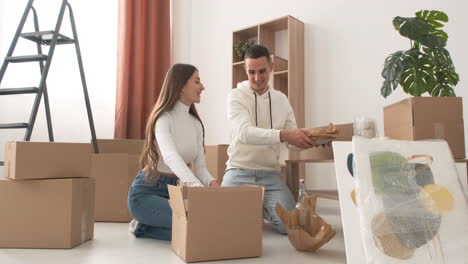 Happy-Couple-Moving-House-Packing-Their-Belongings-And-Kissing