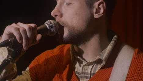 Close-Up-Of-Male-Musician-Playing-Guitar-And-Singing-During-Live-Music-Perfomance