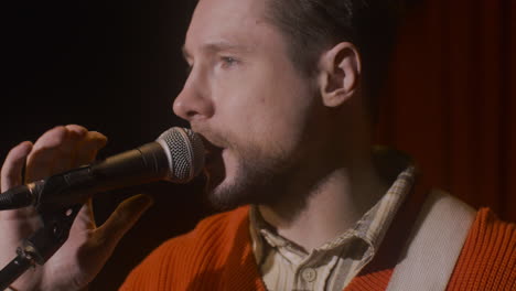 Close-Up-Of-Male-Musician-Talking-Into-Microphone-Before-Live-Music-Perfomance