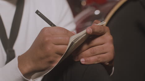 Close-Up-View-Of-Latin-ManÂ¬Â¥S-Hands-Writing-In-The-Notebook-In-Recording-Studio