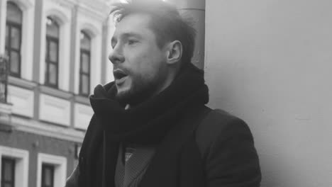 Black-And-White-And-Close-Up-View-Of-A-Man-In-Coat-Singing-And-Playing-Guitar-In-The-Street-1