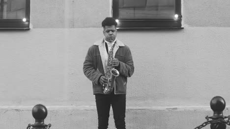 Black-And-White-Of-A-Man-In-Jacket-Playing-Sax-In-The-Street