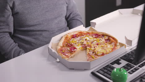 Nahaufnahme-Eines-Nicht-Erkennbaren-Mannes,-Der-Während-Einer-Pause-Im-Büro-Köstliche-Pizza-Isst