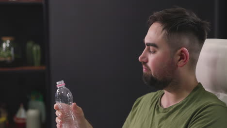 Hombre-Bebiendo-Agua-De-Una-Botella-De-Plástico-En-La-Oficina