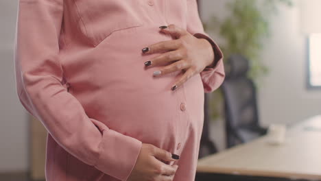 Close-Up-View-Of-Unrecognizable-Pregnant-Woman's-Hands-Caressing-Her-Belly