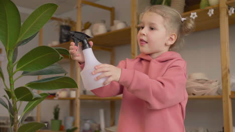 Little-Girl-Spraying-Water-On-A-Plant-At-A-Table-In-A-Craft-Workshop