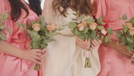 Camera-Focuses-On-Hands-Of-Female-Friends-And-Bride-Holding-Bouquets