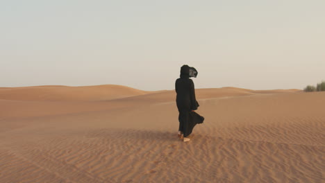 Vista-Trasera-De-Una-Mujer-Musulmana-Con-Hijab-Caminando-Descalza-En-Un-Desierto-Ventoso