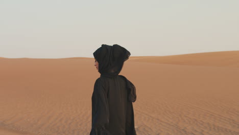 Retrato-De-Una-Hermosa-Mujer-Musulmana-Con-Hiyab-Caminando-En-Un-Desierto-Ventoso-Y-Mirando-A-La-Cámara