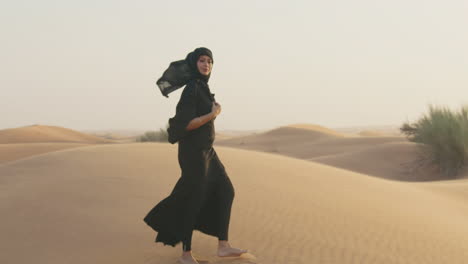 Retrato-De-Una-Hermosa-Mujer-Musulmana-Con-Hiyab-Caminando-En-Un-Desierto-Ventoso-Y-Mirando-La-Cámara-1