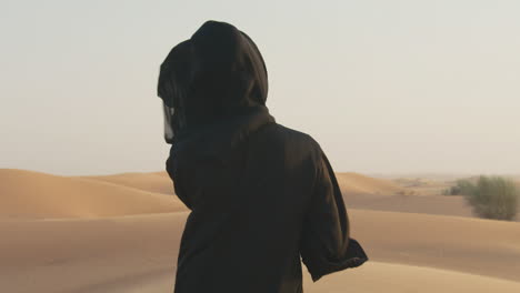 Portrait-Of-A-Beautiful-Muslim-Woman-With-Hijab-Walking-In-A-Windy-Desert-And-Looking-At-Camera-2
