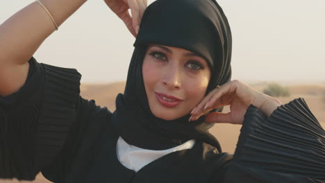 Close-Up-Portrait-Of-Muslim-Woman-Wearing-Hijab-And-Looking-At-Camera-In-A-Windy-Desert