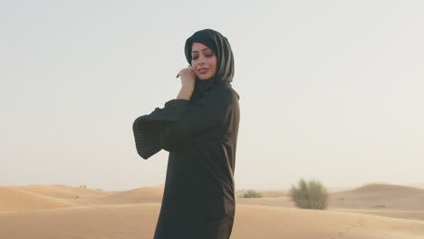 Portrait-Of-A-Muslim-Woman-In-Hijab-Smiling-At-Camera-In-A-Windy-Desert-1