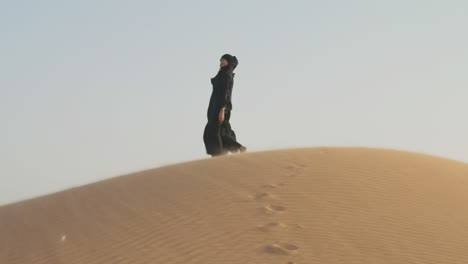 Beautiful-Muslim-Woman-In-Hijab-Walking-Barefoot-In-A-Windy-Desert