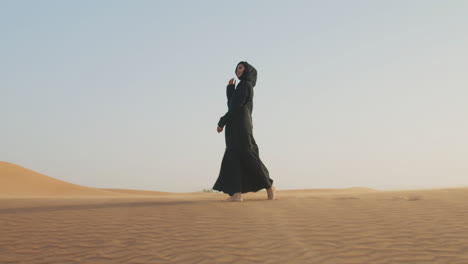 Beautiful-Muslim-Woman-In-Hijab-Walking-Barefoot-In-A-Windy-Desert-3