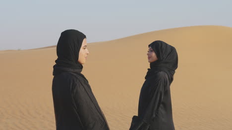 Two-Beautiful-Muslim-Women-In-Hijab-Standing-In-A-Windy-Desert