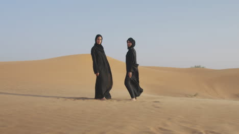 Two-Beautiful-Muslim-Women-In-Hijab-Standing-In-A-Windy-Desert-And-Smiling-At-Camera-2