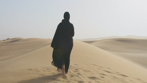 Back-View-Of-A-Muslim-Woman-With-Hijab-Walking-Barefoot-In-The-Desert-1