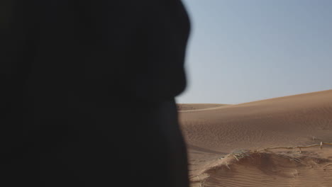 Two-Muslim-Women-Wearing-Traditional-Dress-And-Hijab-Walking-In-A-Windy-Desert