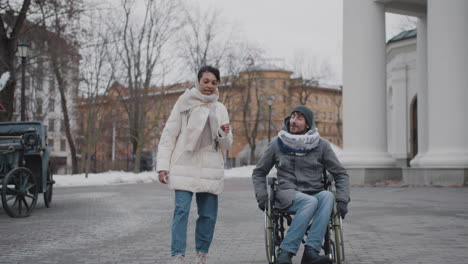 Muslim-Woman-And-Her-Disabled-Friend-In-Wheelchair-Taking-A-Walk-In-City-In-Winter-1