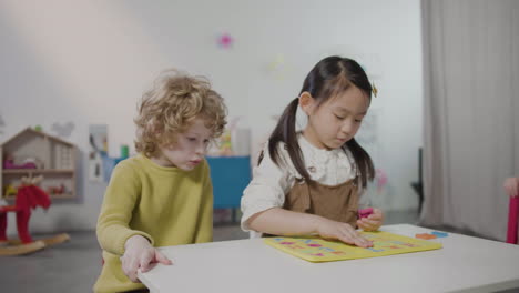 Kleines-Mädchen-Und-Kleiner-Junge-Spielen-Mit-Alphabet-Puzzle-In-Der-Montessori-Schule