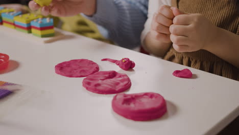 Close-Up-Of-Two-Pupils-In-A-Montessori-School-Playing-With-Shapes-Stacking-And-Play-Dough-While-Teacher-Helping-Them