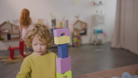 Blond-Little-Boy-Playing-With-Foam-Building-Blocks-In-A-Montessori-School