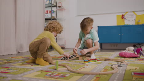 Zwei-Kleine-Jungs-Spielen-Mit-Holzautos-Auf-Dem-Teppich-Im-Klassenzimmer-In-Einer-Montessori-Schule-1