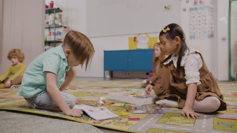 Kleines-Mädchen,-Das-Mit-Verschiedenen-Stücken-Auf-Dem-Teppich-Im-Klassenzimmer-In-Einer-Montessori-Schule-Spielt